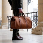 Mann in Anzug mit cognac farbenem Leder Weekender
